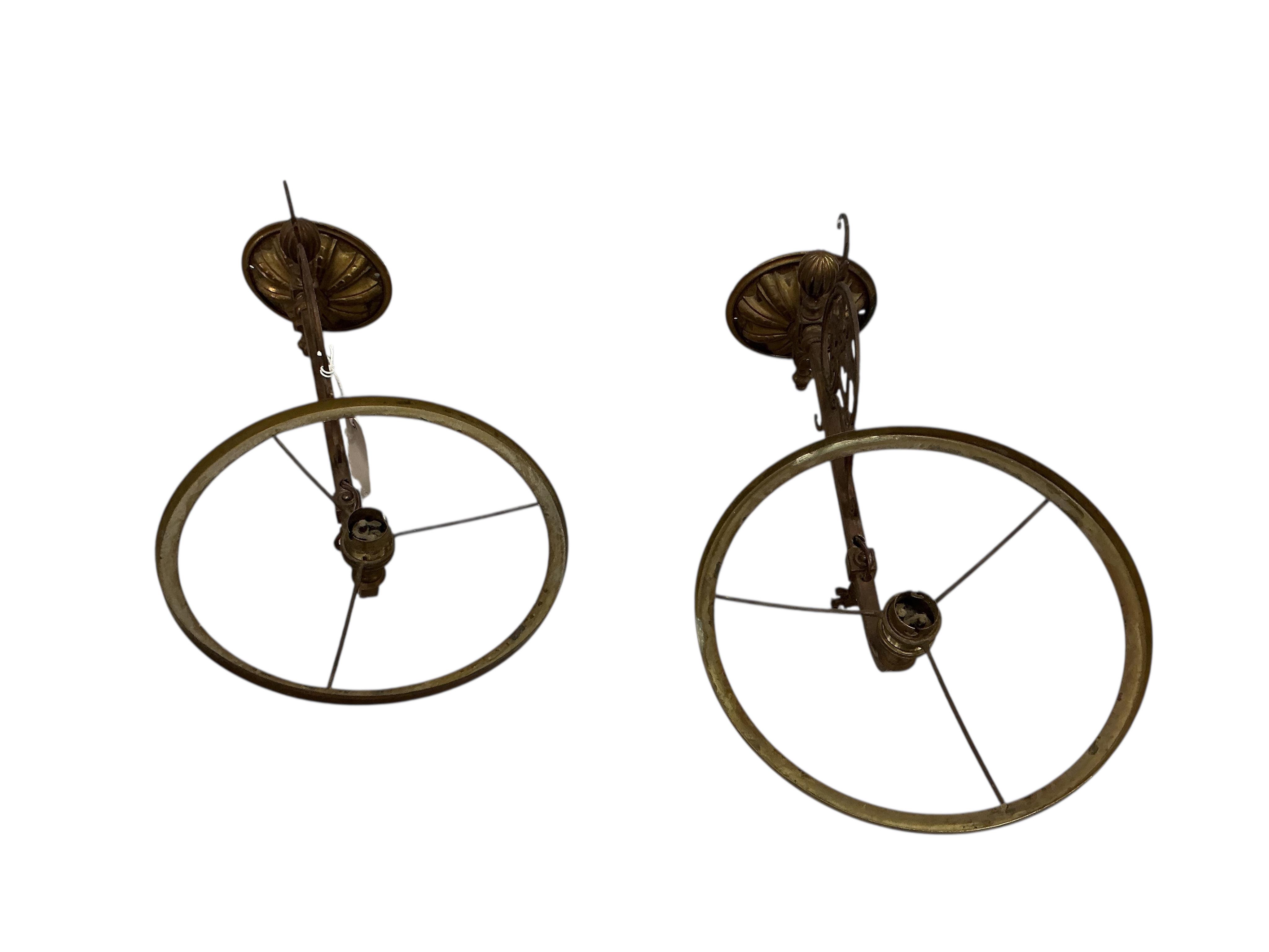 A pair of late Victorian brass wall fitting gas lamps with odd shades (converted), and another electric wall light